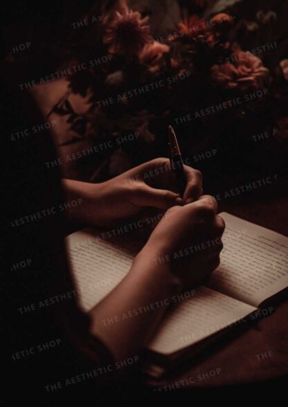 Dark academia aesthetic image of hands writing on a paper in the dark